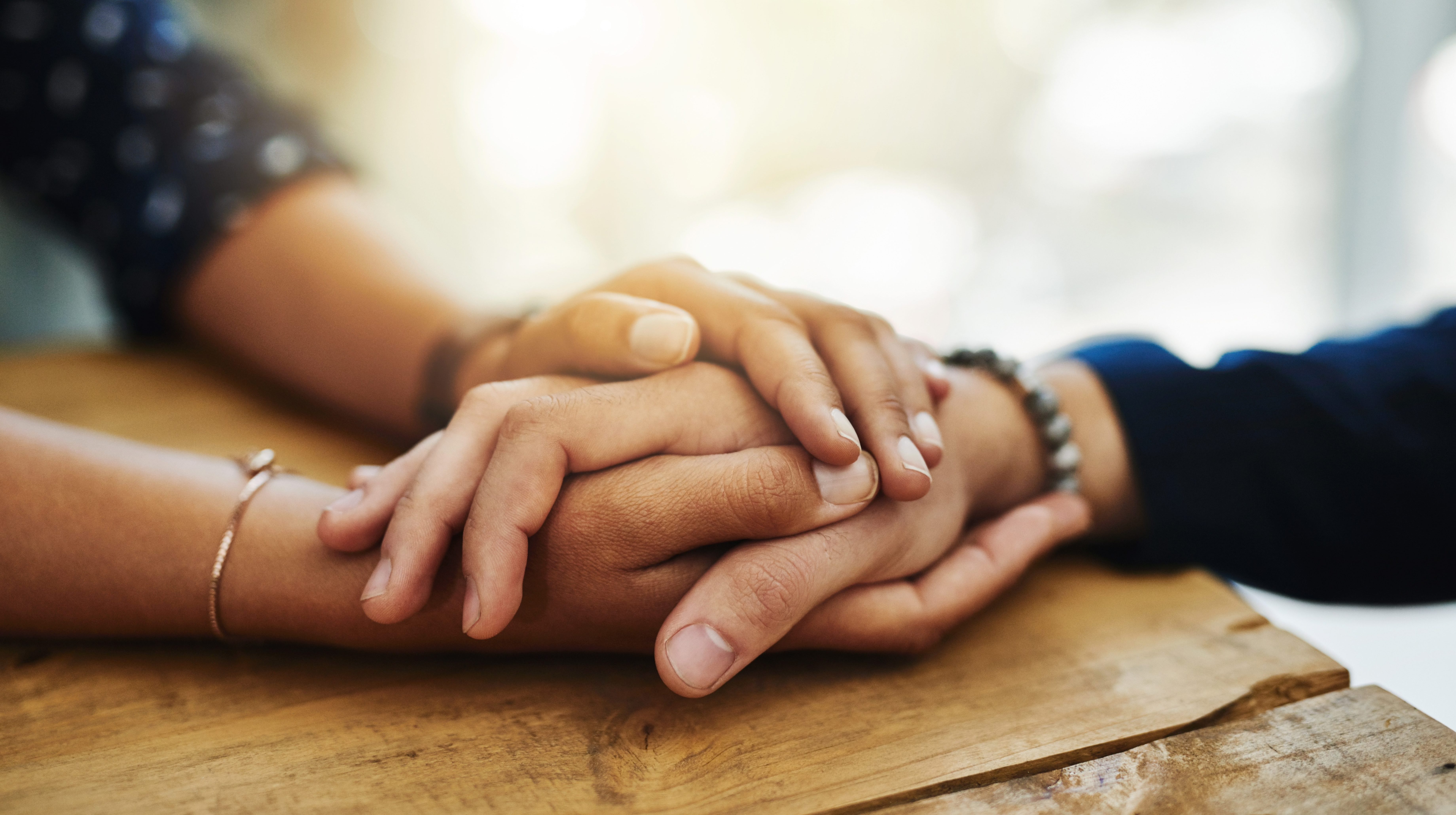 Closeup shot of two unrecognizable people holding hands in comfort